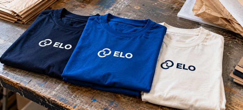 Camisetas com marca empresarial estampada, dobradas na bancada
